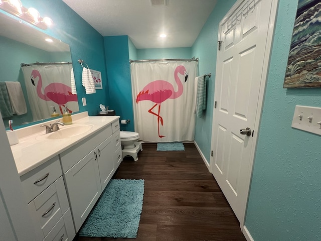 full bathroom featuring vanity, a shower with curtain, wood finished floors, visible vents, and toilet