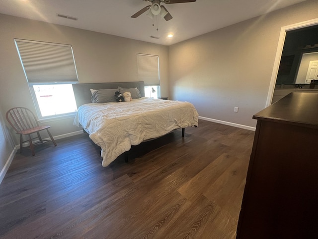 bedroom featuring visible vents, baseboards, dark wood-type flooring, and a ceiling fan