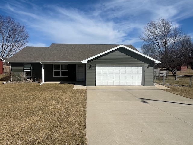 ranch-style home featuring a shingled roof, a front lawn, fence, a garage, and driveway