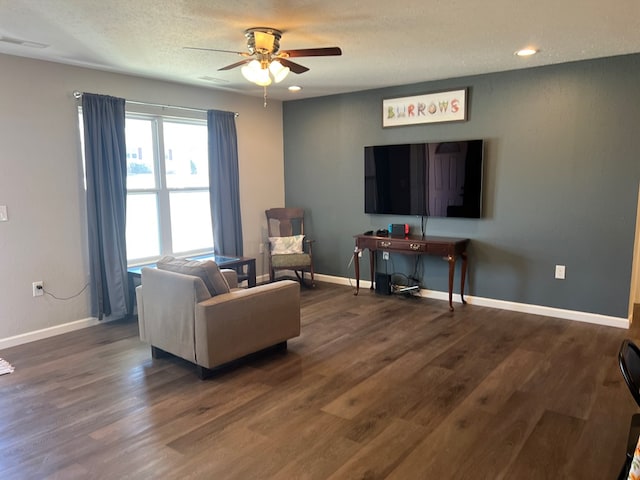 living room featuring visible vents, baseboards, dark wood-style flooring, ceiling fan, and a textured ceiling