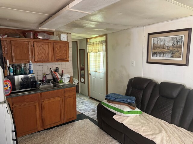 701 Vernon St, Laclede, MO 64651 - kitchen with a sink, brown cabinetry, backsplash, and dark countertops