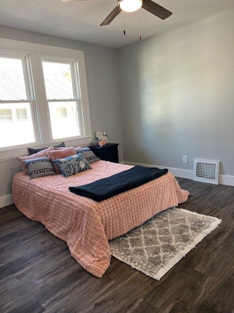 bedroom with ceiling fan and dark wood-type flooring