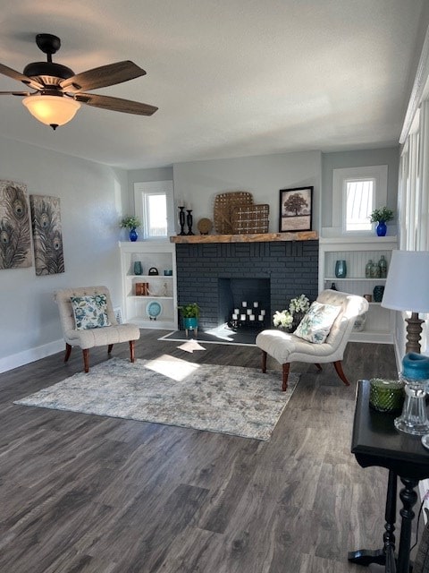 living room with hardwood / wood-style floors, a brick fireplace, and ceiling fan