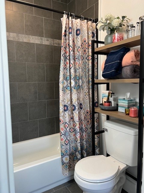 bathroom featuring shower / bath combo with shower curtain, tile patterned flooring, and toilet