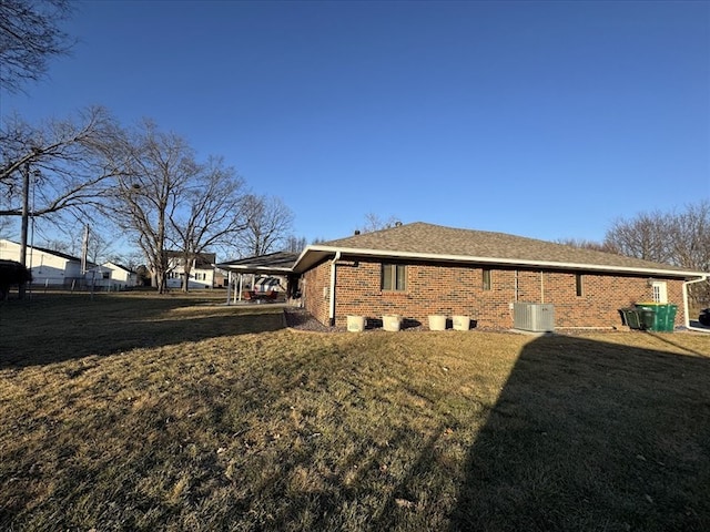 view of side of property featuring a yard, a carport, and central air condition unit