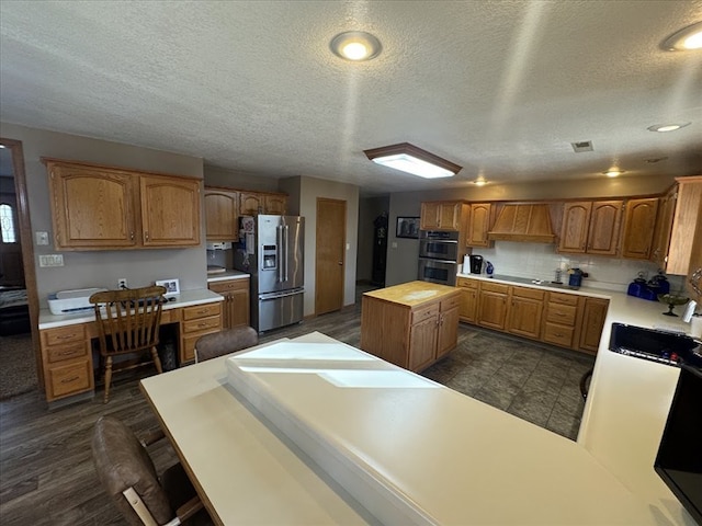 kitchen featuring sink, custom exhaust hood, butcher block countertops, a center island, and appliances with stainless steel finishes