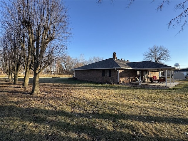 rear view of house with a lawn and a patio area