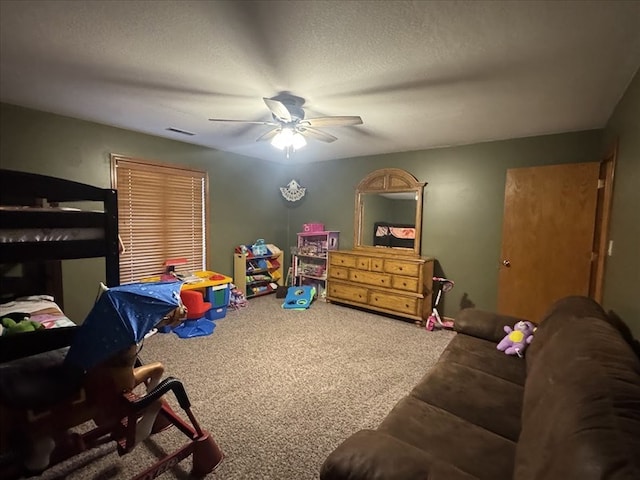 carpeted bedroom featuring ceiling fan and a textured ceiling