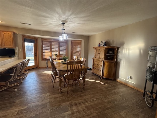 dining room featuring dark hardwood / wood-style floors and a textured ceiling