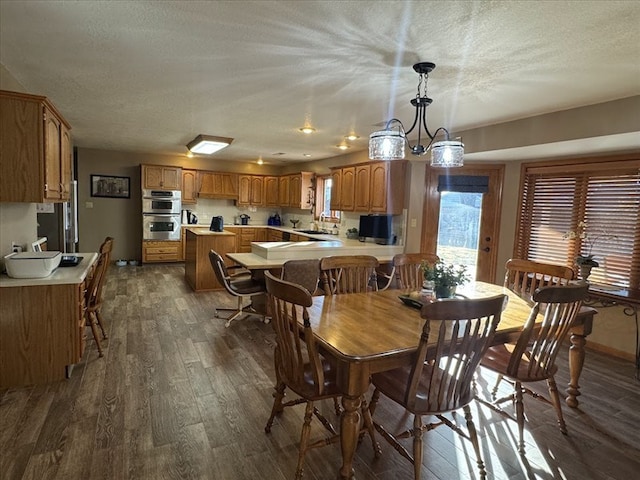 dining space with dark hardwood / wood-style floors, sink, and a textured ceiling