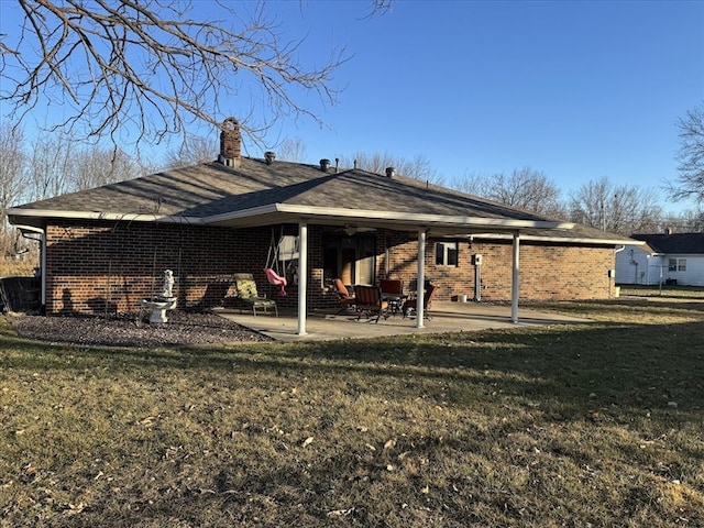 rear view of property featuring a yard and a patio