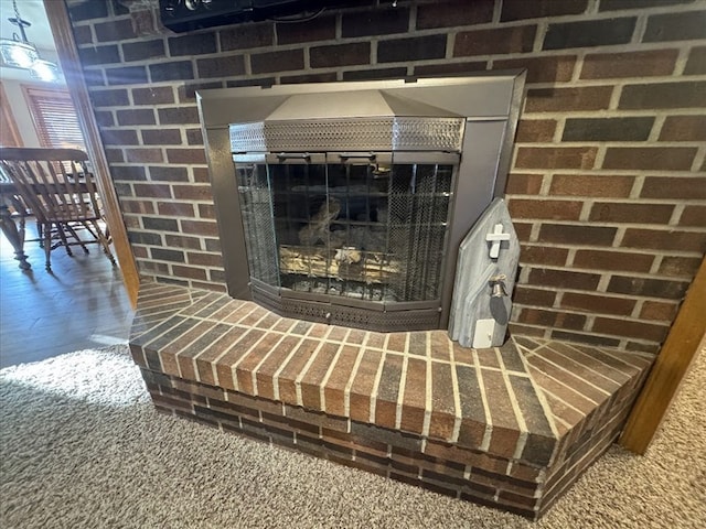 details featuring hardwood / wood-style flooring and a brick fireplace