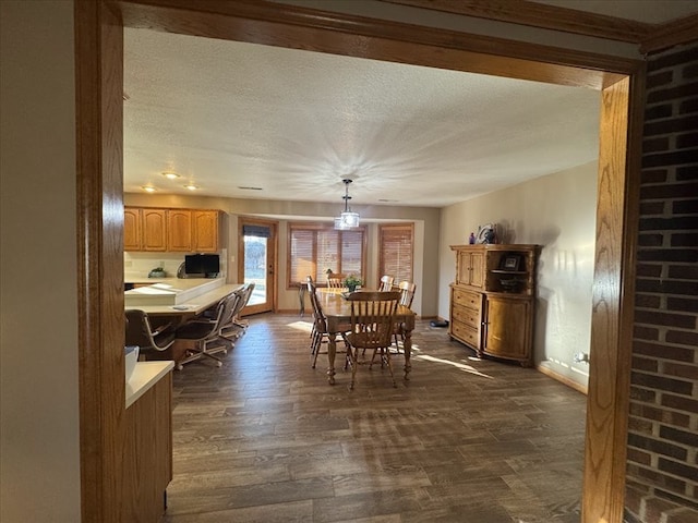 dining room with dark wood-type flooring and a textured ceiling