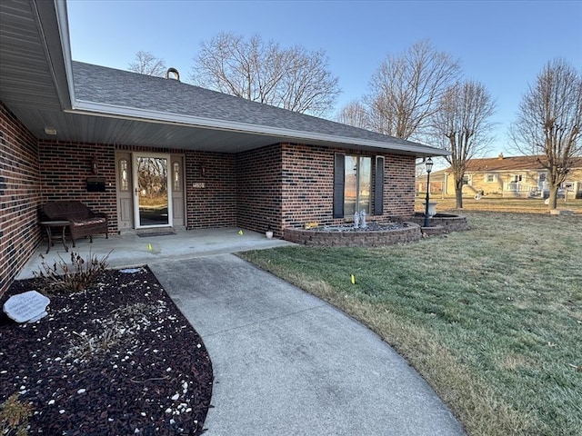 view of exterior entry with a lawn