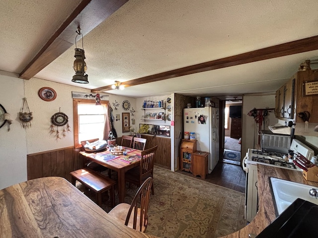 21161 State Highway Ff, Worthington, MO 63567 - dining area featuring beamed ceiling, a textured ceiling, dark wood-style floors, and wood walls
