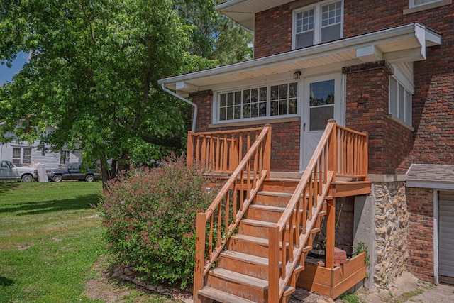 409 E Elm St, Huntsville, MO 65259 - view of exterior entry with brick siding, a yard, and a garage