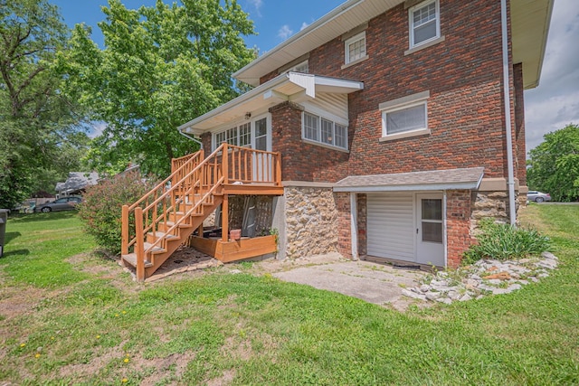 409 E Elm St, Huntsville, MO 65259 - back of house with a yard, brick siding, stone siding, and stairs