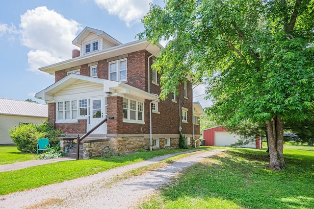 409 E Elm St, Huntsville, MO 65259 - american foursquare style home with an outbuilding, a garage, brick siding, and a front yard