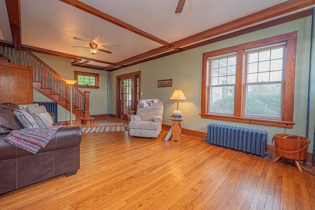 409 E Elm St, Huntsville, MO 65259 - living area with radiator heating unit, a ceiling fan, wood-type flooring, and stairway