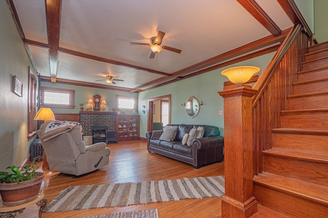 409 E Elm St, Huntsville, MO 65259 - living room featuring a ceiling fan, stairway, hardwood / wood-style flooring, a fireplace, and crown molding