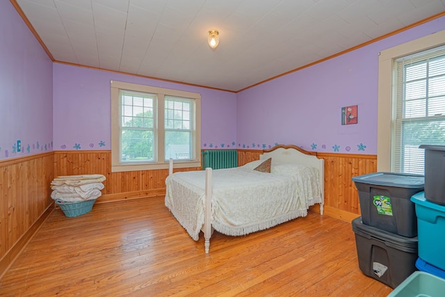 409 E Elm St, Huntsville, MO 65259 - bedroom with multiple windows, wainscoting, ornamental molding, light wood-type flooring, and wood walls