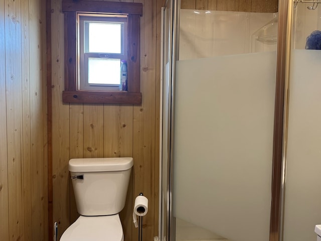 959 Union, Unionville, MO 63565 - bathroom featuring wooden walls, a shower stall, and toilet