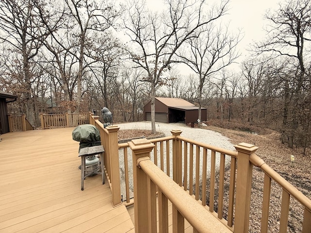 wooden terrace with area for grilling, an outbuilding, and a garage