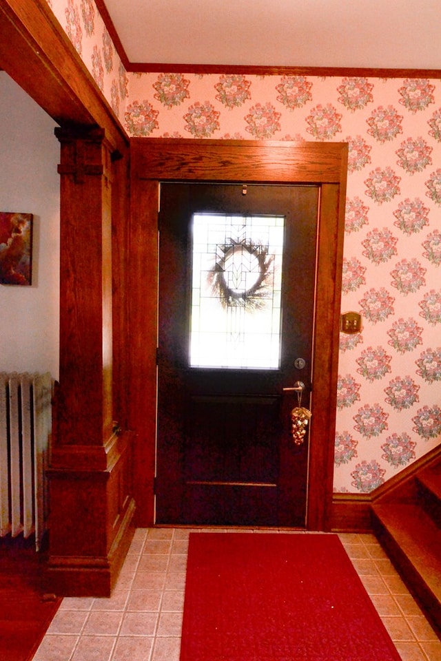 407 E Harrison St, Kirksville, MO 63501 - foyer entrance featuring radiator heating unit, wallpapered walls, light tile patterned floors, decorative columns, and baseboards