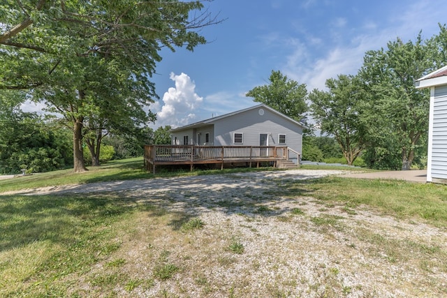 25340 SW Blvd, Bevier, MO 63532 - rear view of property featuring a wooden deck and a lawn