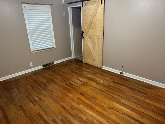 202 W Laharpe St, Kirksville, MO 63501 - spare room featuring a barn door and dark wood-style floors