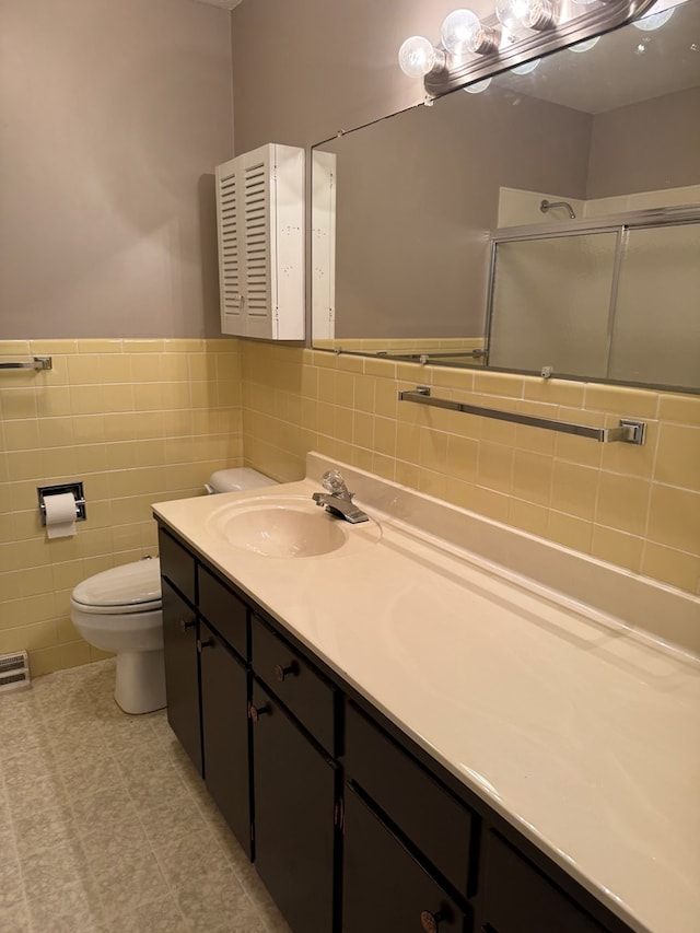 202 W Laharpe St, Kirksville, MO 63501 - bathroom with an enclosed shower, tile walls, double vanity, and a wainscoted wall