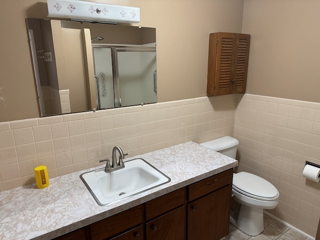 202 W Laharpe St, Kirksville, MO 63501 - bathroom with tile walls, vanity, a stall shower, tile patterned flooring, and a wainscoted wall