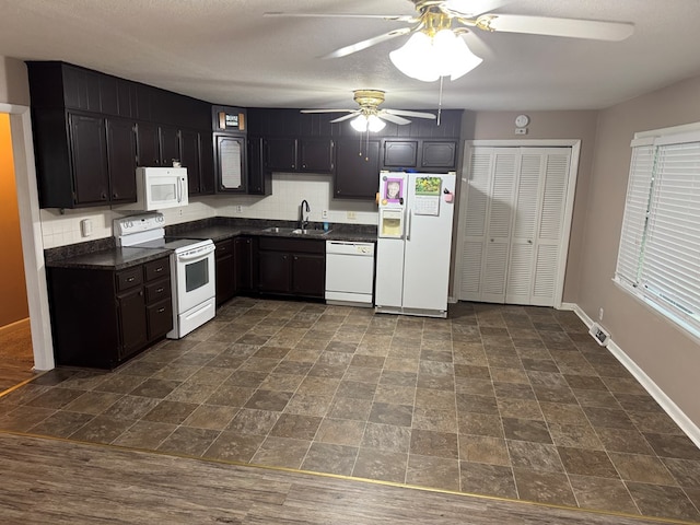 202 W Laharpe St, Kirksville, MO 63501 - kitchen with white appliances, dark countertops, ceiling fan, stone finish floors, and backsplash