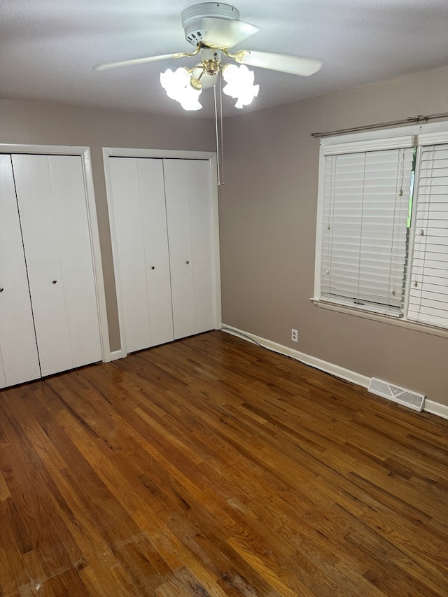 202 W Laharpe St, Kirksville, MO 63501 - unfurnished bedroom with wood finished floors, two closets, and a ceiling fan