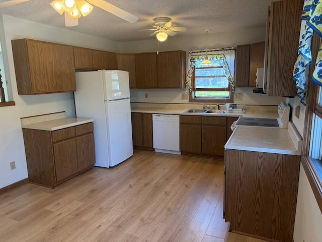 1214 E Washington, Kirksville, MO 63501 - kitchen with white appliances, a textured ceiling, a ceiling fan, light countertops, and brown cabinets