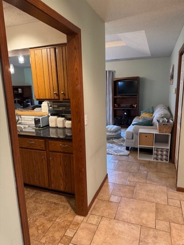34829 State Highway C, Bevier, MO 63532 - kitchen with dark countertops, brown cabinets, open floor plan, and light stone finish floors