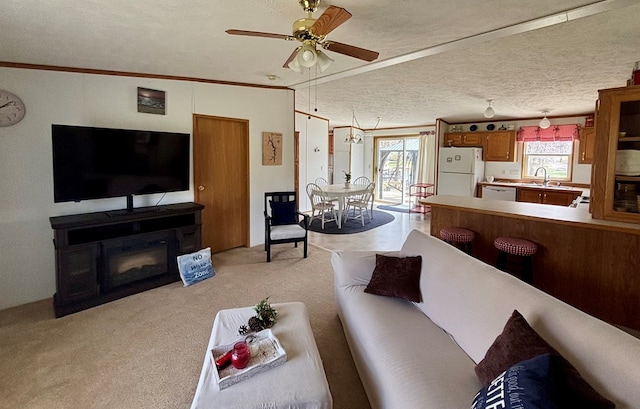 living area with light colored carpet, ornamental molding, and ceiling fan