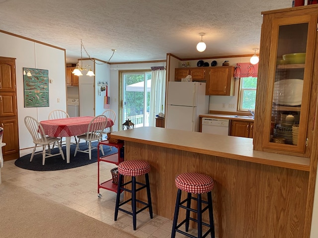 kitchen featuring a kitchen breakfast bar, white appliances, a peninsula, crown molding, and light floors