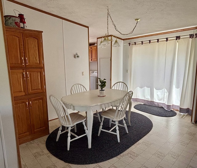dining space with washer / clothes dryer, crown molding, a textured ceiling, and light floors