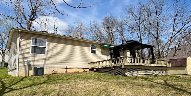 rear view of house featuring a wooden deck, a lawn, and central air condition unit