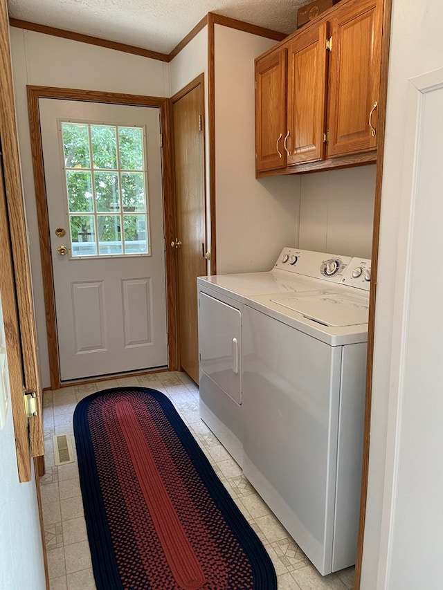 laundry room featuring visible vents, washer and clothes dryer, a textured ceiling, and cabinet space