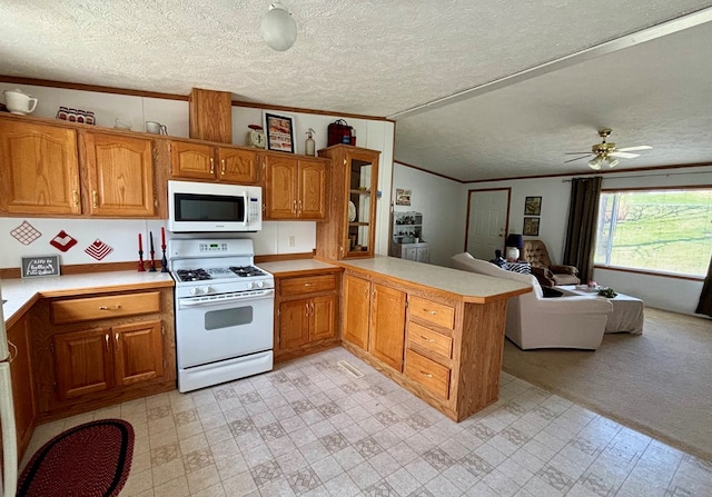 kitchen with ornamental molding, white appliances, a peninsula, a textured ceiling, and brown cabinetry