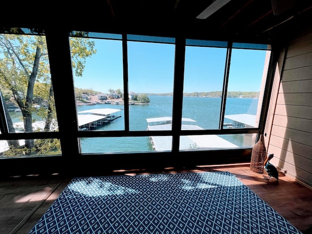 sunroom featuring a water view