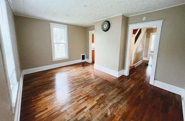 spare room with dark hardwood / wood-style flooring and crown molding