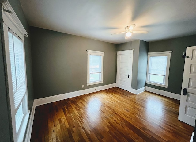 unfurnished bedroom with multiple windows, wood-type flooring, and ceiling fan