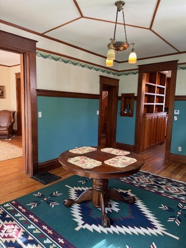 unfurnished dining area featuring hardwood / wood-style floors and ornamental molding