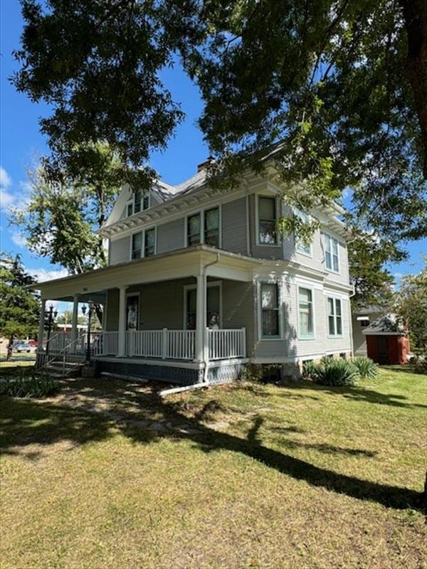 view of front of property featuring covered porch and a front yard