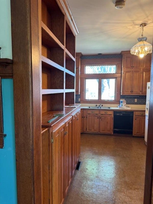 kitchen featuring tasteful backsplash, sink, pendant lighting, a chandelier, and black dishwasher