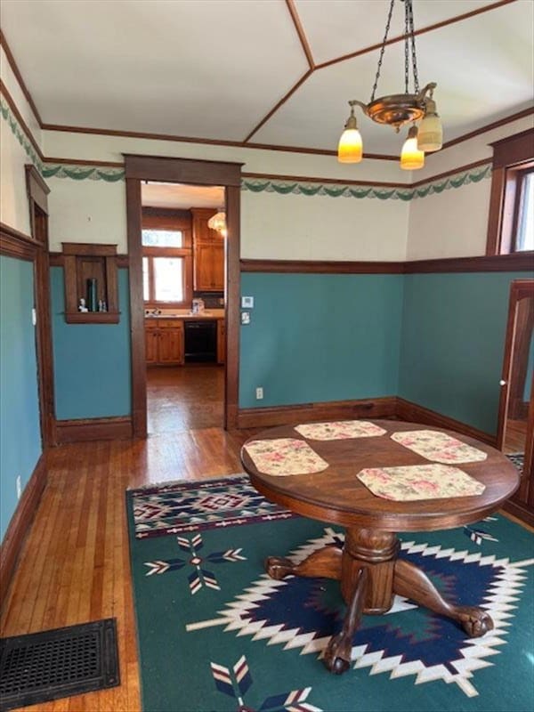 unfurnished dining area featuring dark hardwood / wood-style flooring and crown molding