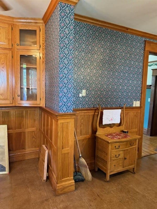 bathroom featuring ornamental molding and wooden walls